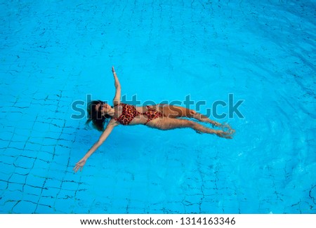 Aerial view of girl in swimming pool from above