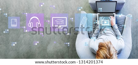 E-Learning with man using a laptop in a modern gray chair Royalty-Free Stock Photo #1314201374