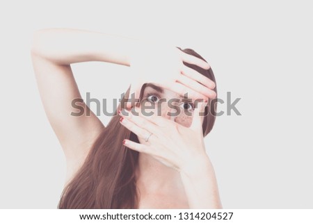 Portrait of smiling young woman making a hand frame isolated on white background
