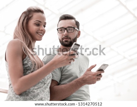young couple looking at the screens of their smartphones
