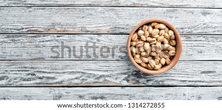 Pistachios on a white wooden background. Top view. Free space for your text.