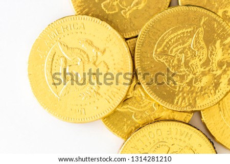 Gold foiled wrapped chocolate coins on a white background