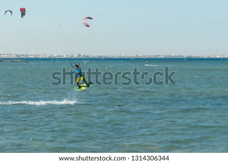 Kitesurfing Kiteboarding action photos man among waves quickly goes. A kite surfer rides the waves. lens illumination. toned