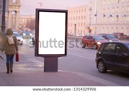 vertical billboard for posters, city format, illuminated sign near the road People walking about advertising. outdoor advertising white mockup for advertising