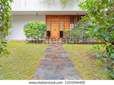 contemporary house garden with stone path to the wooden entrance door, Athens Greece