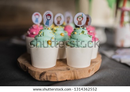 Child Birthday Party Close Up Green and Rose Sweet Cupcakes Colorful with Sprinkles and Cream Cheese Tiger Pirate Penguin and Sloth Plug