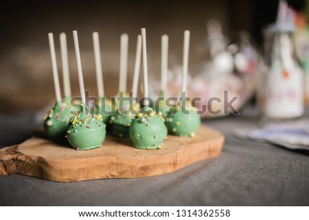 Child Birthday Party Green Cake Pops with Yellow Colorful Sprinkles on Wooden Table Close Up Portrait