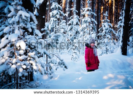 Girl is walking on a winter day in the forest