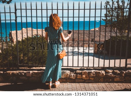 Girl taking a picture with a smartphone in Ancient roman amphitheater of Tarragona, Spain.The Archaeological Ensemble of Tarraco is declared a UNESCO World Heritage Site Ref 875