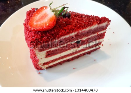 Slice of tasty red velvet cake with strawberry topping