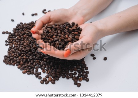 Coffee beans in woman's hands.