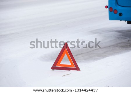 The emergency stop sign stands on an icy snow-covered road