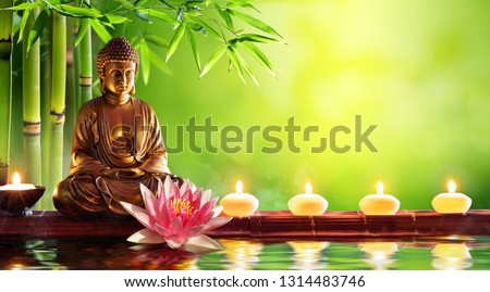 Buddha Statue With Candles In Natural Background Royalty-Free Stock Photo #1314483746