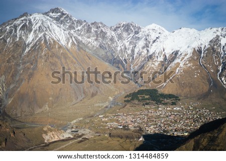 Clouds over snow-covered rocks. Mountain peaks in clouds. Clouds over snow-capped mountains .Mountains against blue sky. Beautiful mountain landscape.
