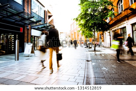 Abstract motion blurred shoppers on UK high street Royalty-Free Stock Photo #1314512819