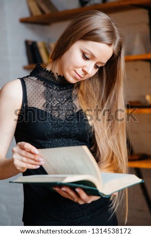 A young girl in black clothes is reading a book. A blond woman holds a book.