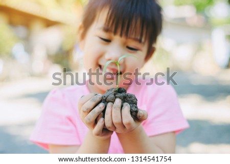 Cute kid planting a tree for help to prevent global warming or climate change and save the earth. Picture for concept of Mother Earth Day to encourage people about the environmental protection.