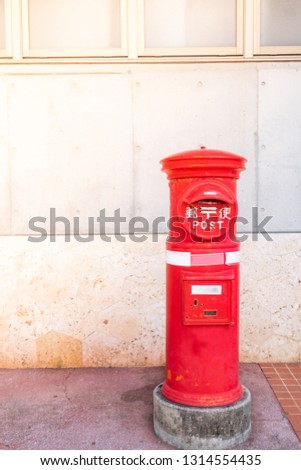 classic vintage Japanese style postbox with cement wall background, Red English pillar box 