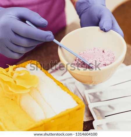 Closeup photo of cosmetologist's hands mixing ingredients for peeling mask