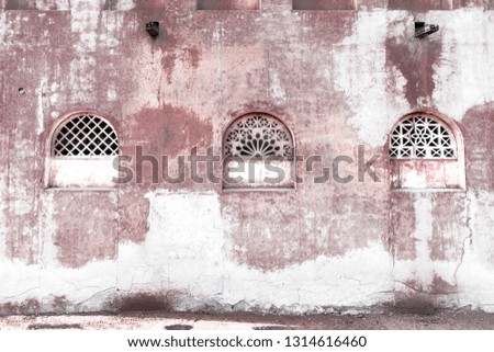 Old wall of eastern architecture with a patterned lattices on the windows. Art