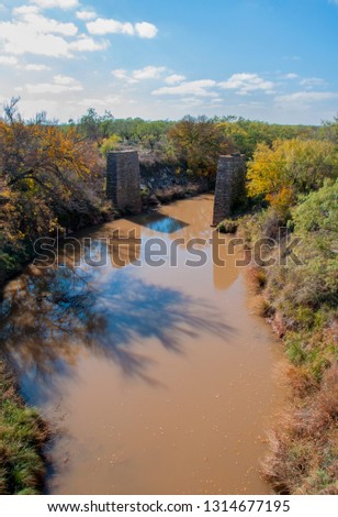 Very muddy river and the base of the destroyed old bridge in Texas.