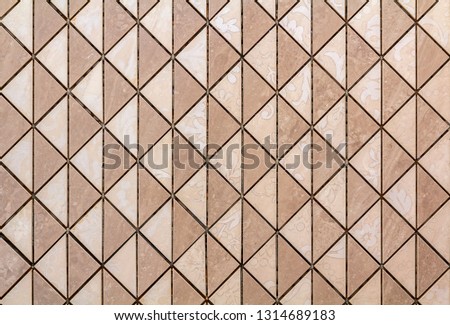 Beige tiles wall or floor with light floral decoration. Repeating graphic design, flat surface, geometrical background.