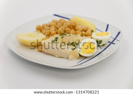 typical portuguese dish boiled codfish with grain, onions, boiled egg , olive oil, pepper and parsley, portugal, slice loins