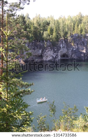 beautiful views of the lake in blue and green colors that surround the marble rocks overgrown with fir forest