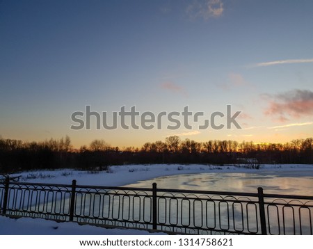 Bridge by the river. Winter bridge. Bridge in the winter at sunset.