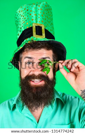 Saint Patrick's Day. Happy four leafed clover. Saint Patrick's Day symbols. Bearded man in green top hat holds clover. Patricks Day green shamrock. Ireland tradition.