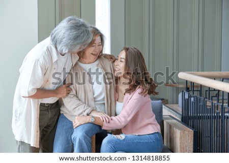 Parents and daughters happily embrace each other in the living room while taking pictures together within the family.