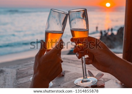 Glasses of champagne on the beach with a red sunset Royalty-Free Stock Photo #1314855878