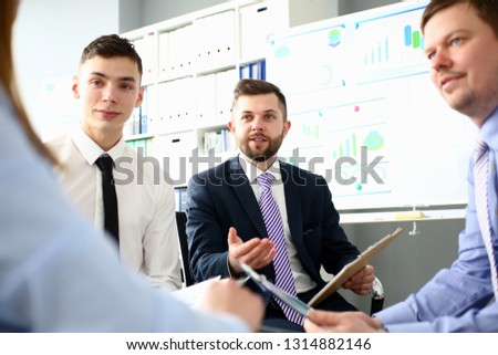 Young handsome teacher man in suit with workgroup seminar board with chart coaching background. Lecturer for applicants retraining financial statistics management enterprise etiquette corporate spirit