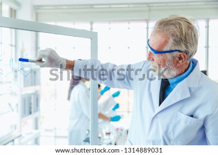 Science teacher men working with transparent glass board chemicals in lab