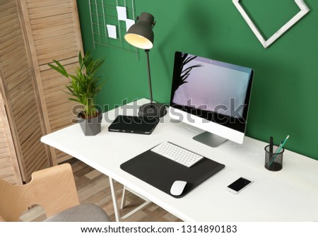 Stylish workplace with modern computer near color wall. Space for text