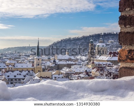 The view of snowy Old Town buildings captured from the Prague Castle outlook in the winter morning. Prague, Czech Republic. Royalty-Free Stock Photo #1314930380