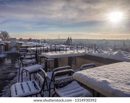 The view of snowy Old Town buildings captured from the Prague Castle roof top cafe in the winter morning. Prague, Czech Republic.
