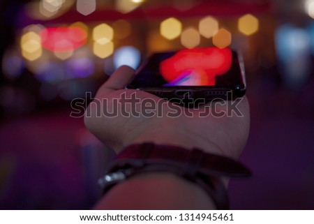 Male hands with smartphone and night street on background

