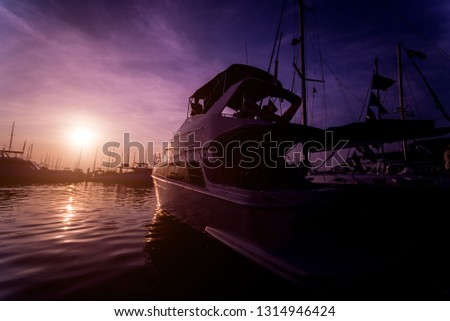 Beautiful view of marina and harbor with yachts and motorboats. Sunset at the ocean. Background