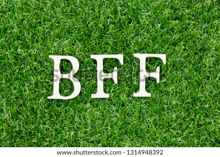 Wood letter block in word BFF (Abbreviation of best friend forever) on artificial green grass background