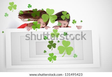 Girls looking down at placard with shamrocks for st patricks day