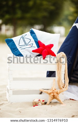 Decorative composition in marine style. Decorative cushion, sea stars, pillows and anchor. Beach holidays and vacation, relax