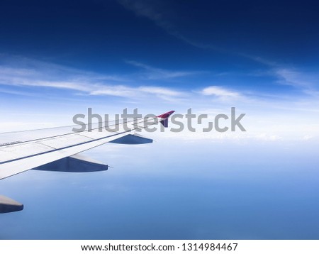 A Picture of Airplane Wing over Sea with clear sky.