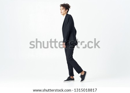 Handsome elegant man in black suit in full growth office worker