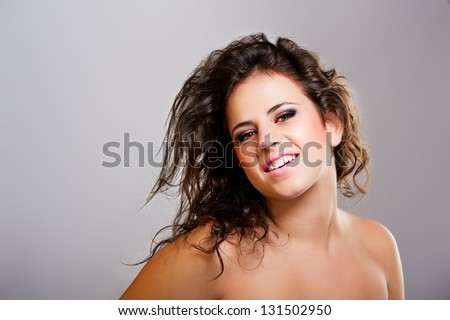Closeup portrait of cute young teenage girl smiling against gray background