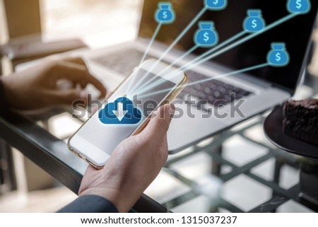 Businessman using smartphone or cellphone to invest money online and connecting to laptop
