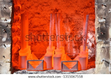 Red hot parts in an electric furnace for hardening metal. Hardening of metal parts at the valve manufacturing plant. Dangerous work, close up