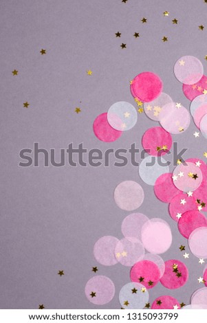 Pink confetti with gold stars on gray background with copyspace