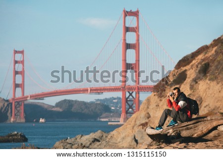 Travel in San Francisco, tourist man with camera in front of Golden Gate Bridge, San Francisco, California, USA