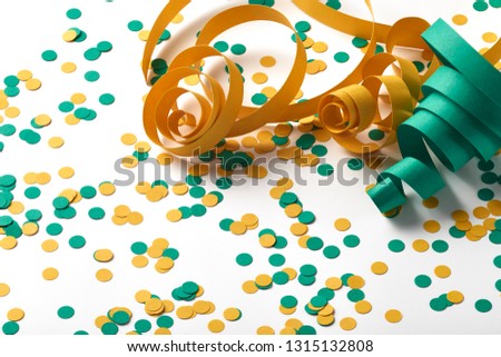 Carnival background with confetti and green and yellow serpentine spaced on white background